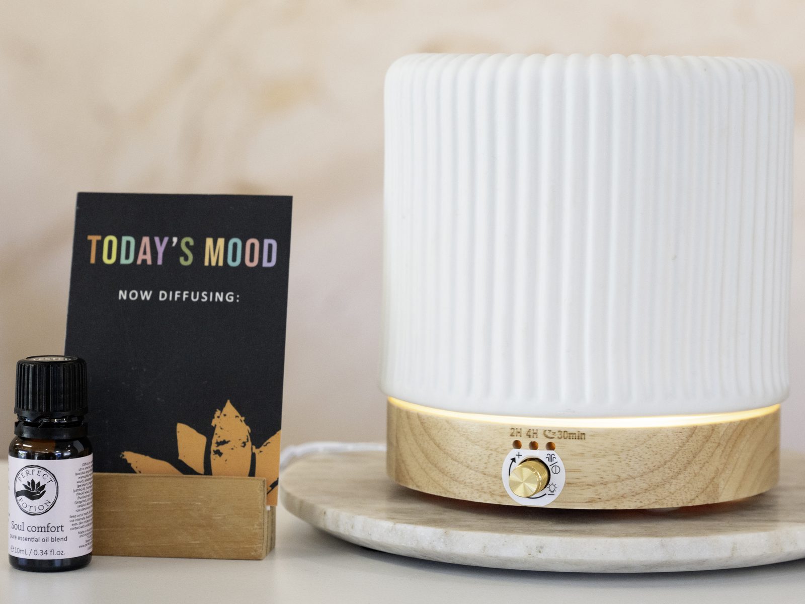 An essential-oil diffuser on a marble board with a 'today's mood' card