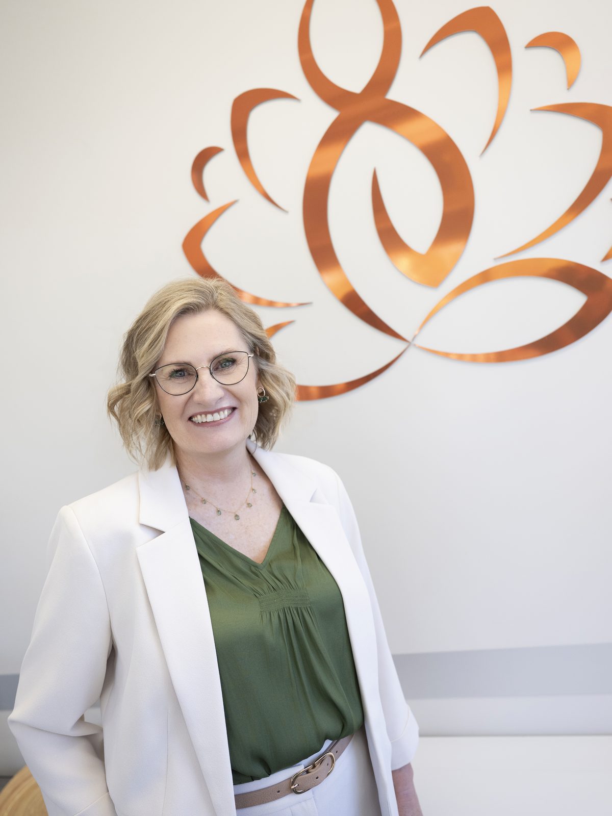 Dr Ilze Grobler standing beside the copper lotus emblem at reception